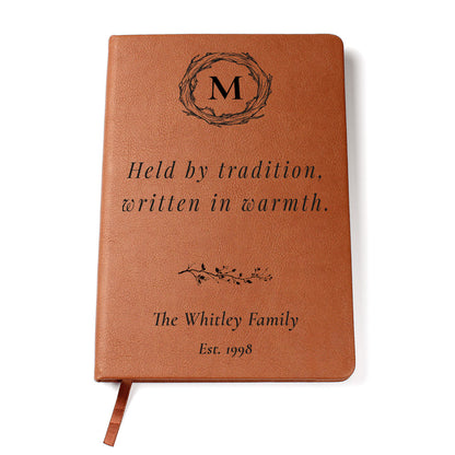 Brown leather notebook with engraved text and monogram on a white background